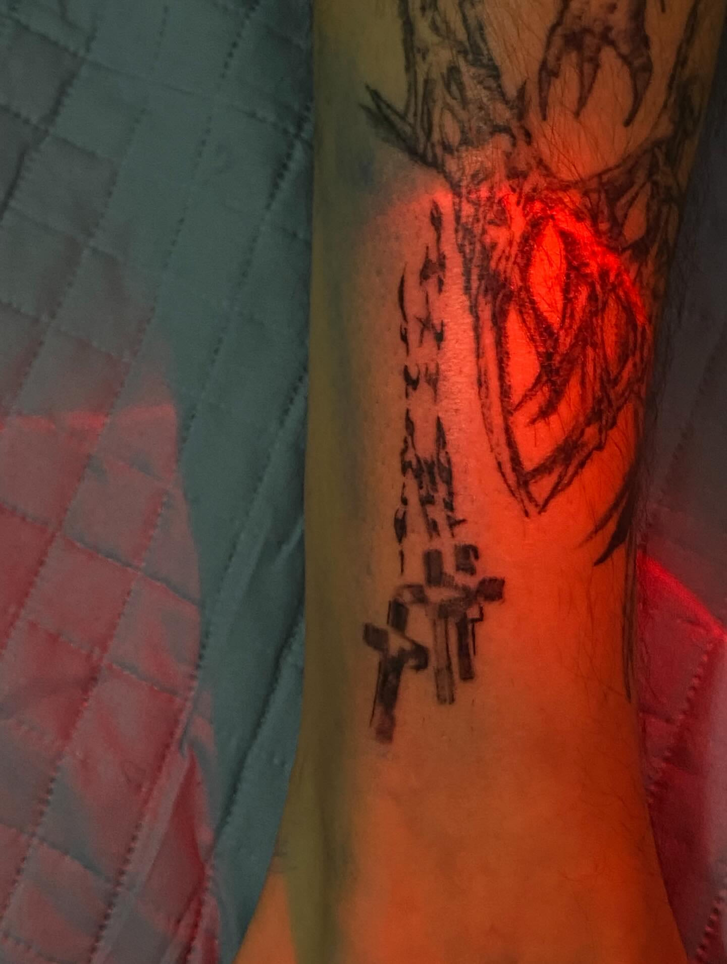 Rosary with crosses down the forearm, photographed under red light