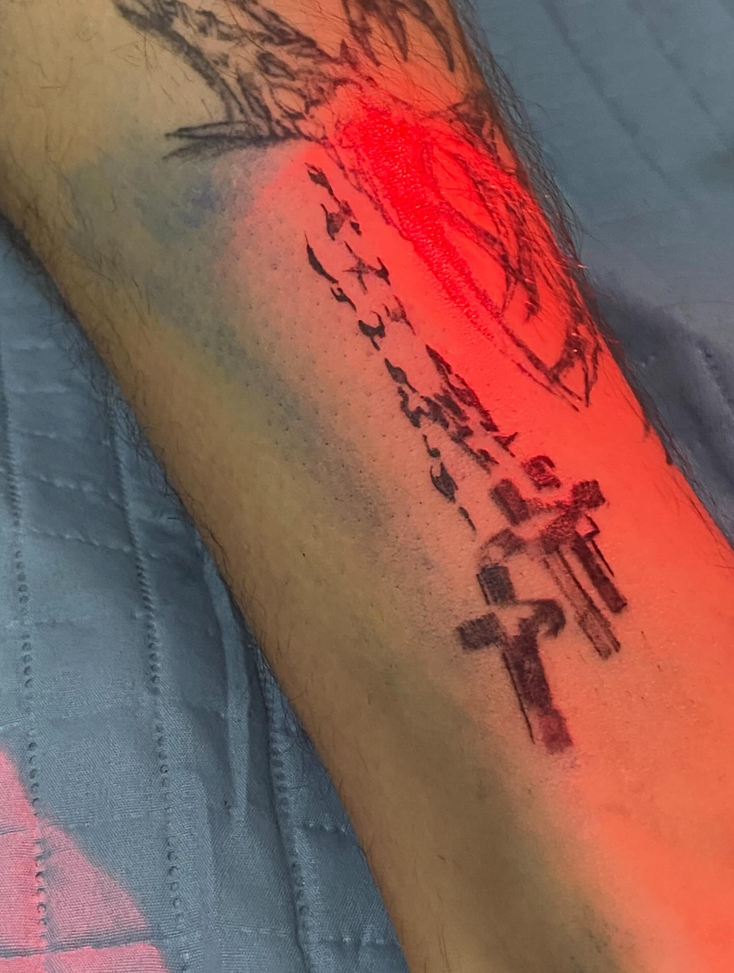 Rosary and cross on the forearm under red light, second angle