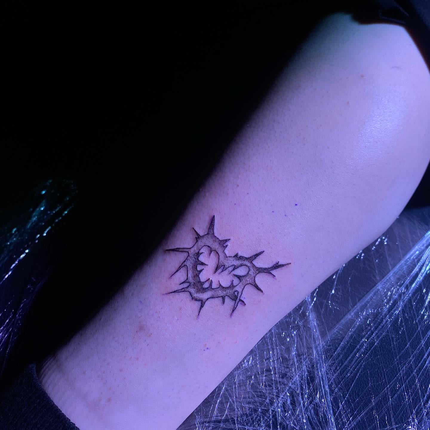 Spiked heart sigil under film, violet light, second angle