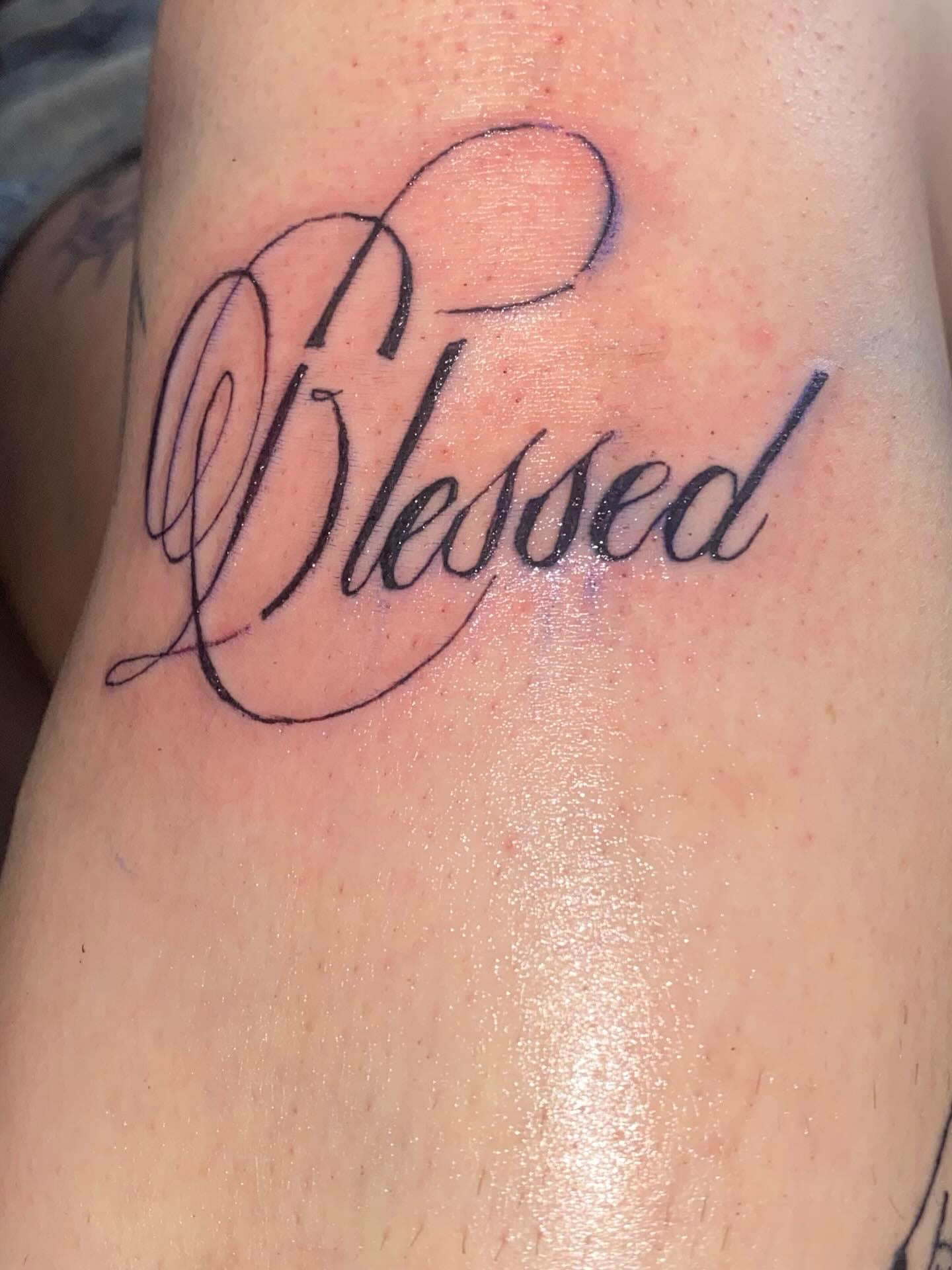Blessed script lettering on the thigh, fresh