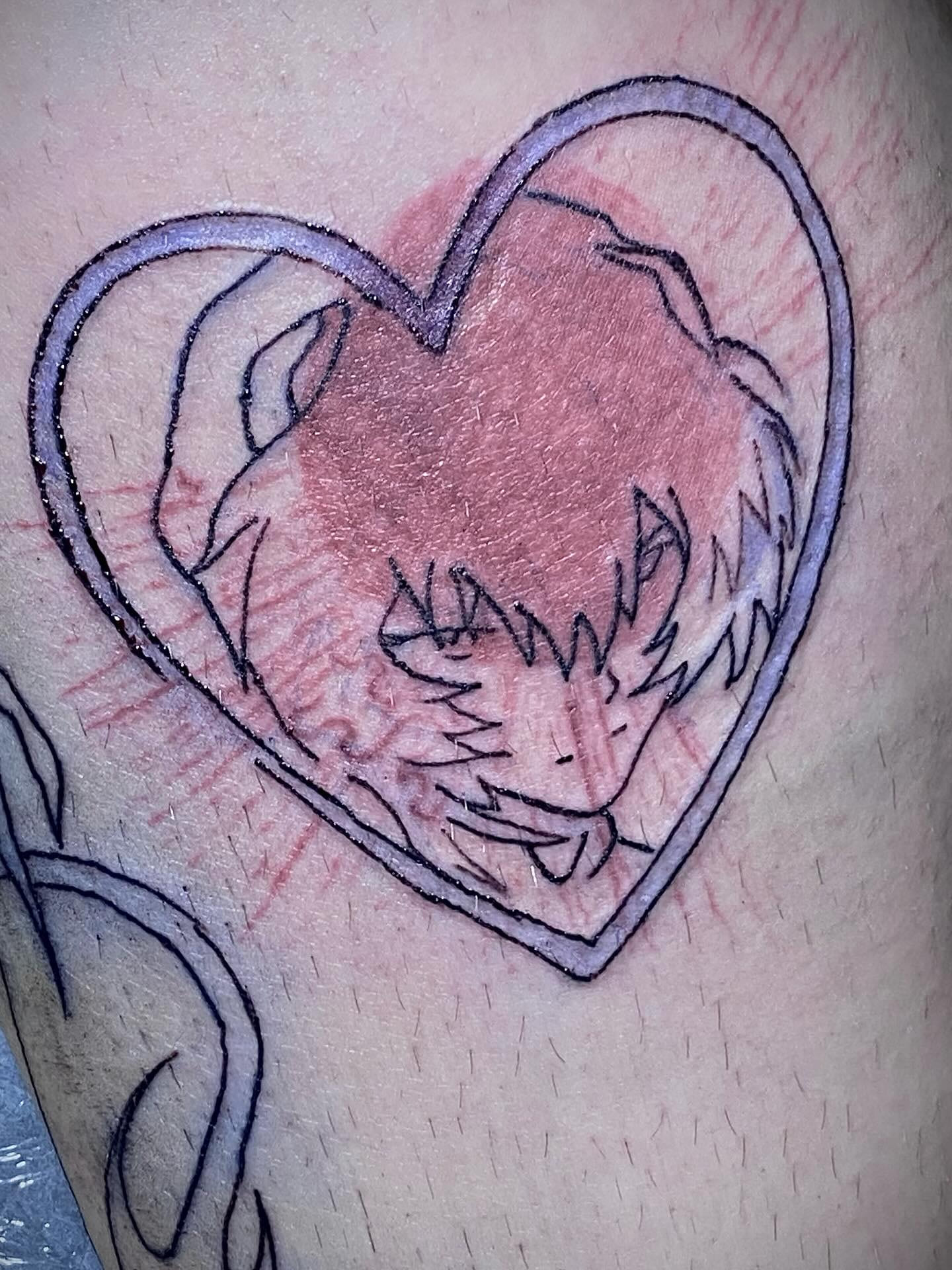 Heart with an anime face inside, above the knee, freshly lined