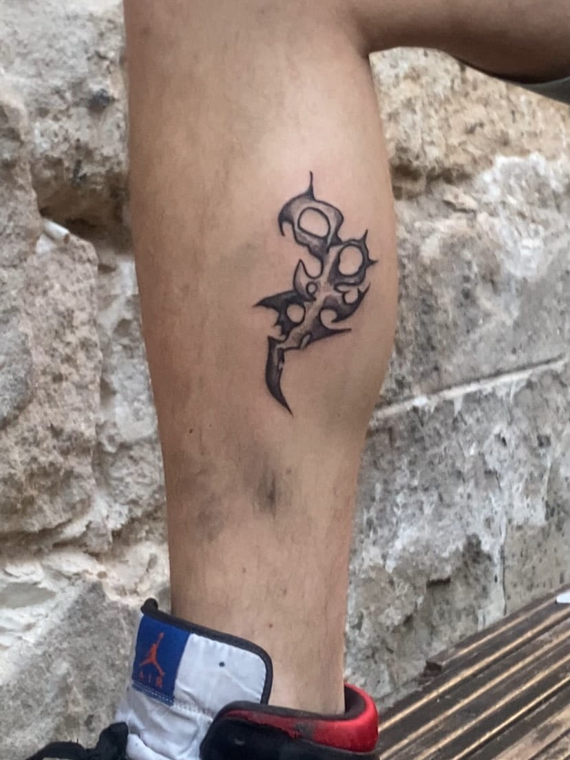 Small spiked sigil on the calf, healed, outdoors