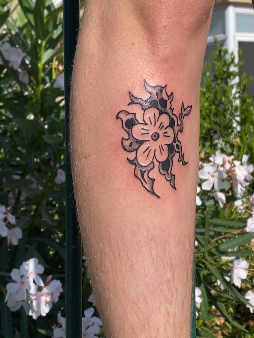Flower with tribal blades on the calf, healed, daylight