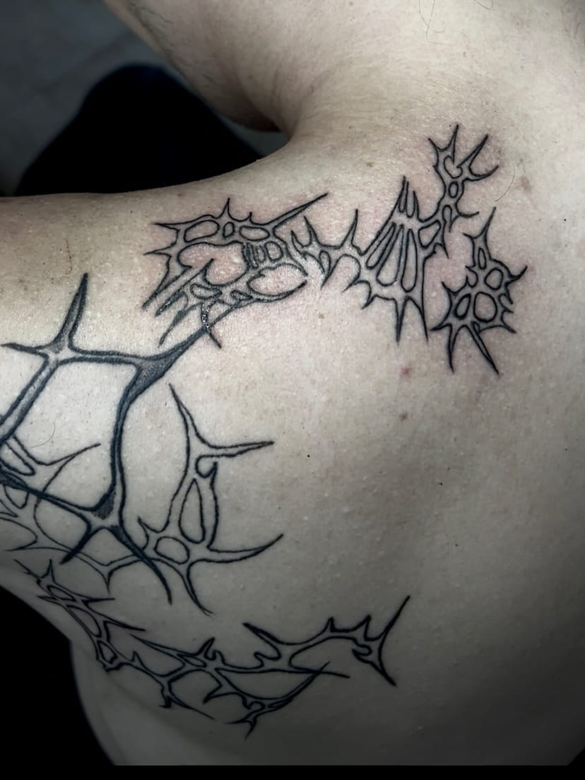 Thorn network spreading across the upper back, fresh